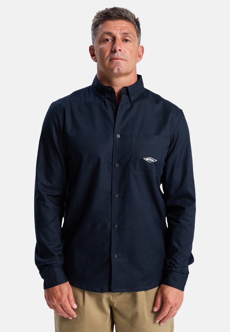 Marineblauwe overhemd met knopen van katoen, met lange mouwen, een borstzak en een klein logo boven de zak.