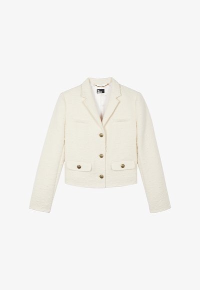 Veste courte blanche en tissu texturé, dotée d'un col à revers, de deux poches avant et de boutons ton or.