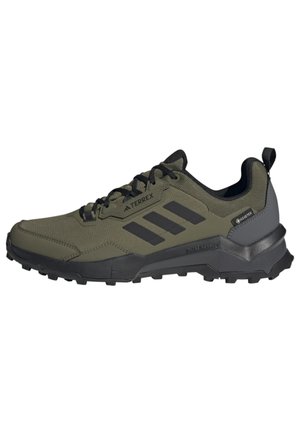 Chaussure de randonnée Adidas Terrex vert olive et noire avec semelle robuste, fermeture à lacets, étiquette Gore-Tex et languette de tirage à l'arrière.