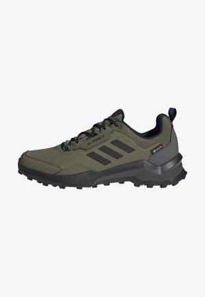 Chaussure de randonnée Adidas Terrex vert olive et noire avec semelle robuste, fermeture à lacets, étiquette Gore-Tex et languette de tirage à l'arrière.