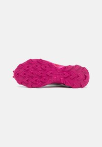 Suela de zapato para correr en senderos de goma rosa brillante. Presenta un patrón de banda de rodadura agresivo con tacos multidireccionales para la tracción. Material duradero y flexible.