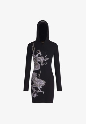 Vestido negro con capucha y mangas largas; presenta un diseño gráfico de un dragón plateado. Hecho de tela acanalada con una silueta ajustada.