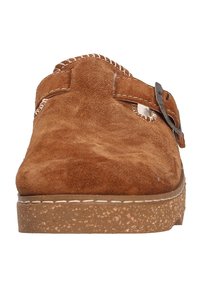 Brown suede clog with a textured surface, a front strap with metal buckle, and a textured rubber sole. Features white stitching accents.