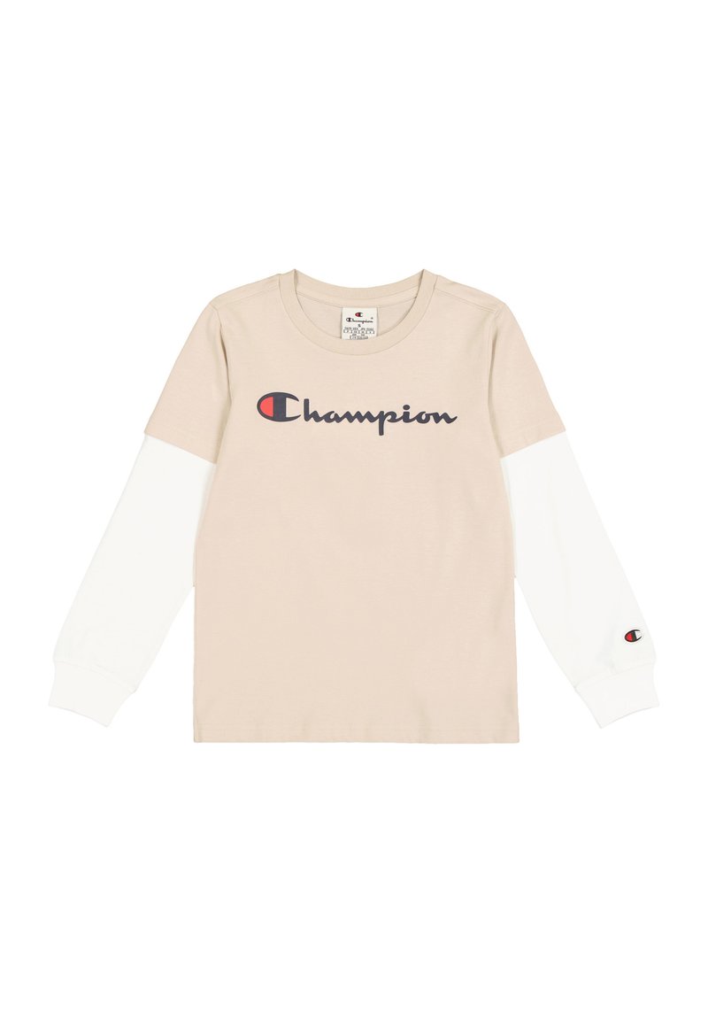 Beige T-shirt met lange mouwen en witte mouwen, met een groot marineblauw 'Champion' logo over de voorkant en een klein logo op de mouw.