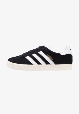 Black suede sneaker with white leather accents and three white stripes. Features a textured rubber sole and gold "Gazelle" logo detail.