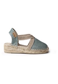 Modré a béžové espadrilky s tkaným vrchom, elastickými krížovými popruhmi a pletenou juty podrážkou. Hladká textúra a zaoblený dizajn špičky.