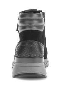 Zwarte enkellaars met een combinatie van suede en leer, voorzien van een textuur met gebarsten accent op de hak en een gewatteerde kraag.