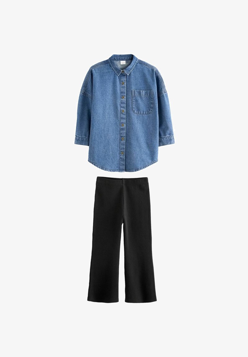 Niebieska koszula z denimu z guzikami i kieszenią, zestawiona z czarnymi szerokimi spodniami. Obie części mają swobodny krój i mocny materiał.