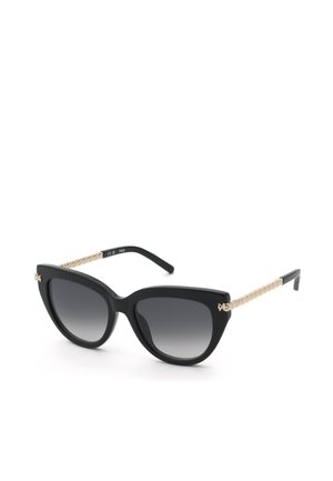 Lunettes de soleil cat-eye noires avec verres foncés dégradés et branches dorées texturées, affichées sur fond blanc.