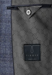 Blue textured suit jacket lining with a gray patterned interior, a white button, and a black label reading "TIEOFF by Marlane."