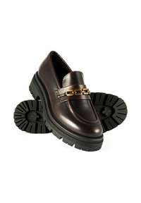 Ciemno-bordowe skórzane mokasyny z złotym łańcuszkiem na cholewce oraz masywną czarną kauczukową podeszwą z bieżnikiem.