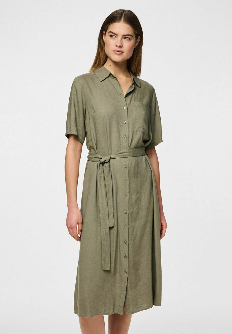 Abito camicia verde khaki realizzato in tessuto texture, dotato di un colletto, maniche corte, davanti con bottoni e vita con cintura.