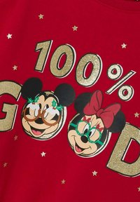 Felpa rossa con la scritta "100% BUONO" in glitter dorato, con i volti dei cartoni animati di Mickey e Minnie Mouse che indossano occhiali festivi e circondati da stelle dorate.
