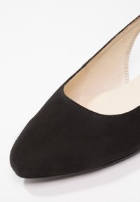 Chaussure noire en daim à bout pointu avec une coupe basse et une doublure intérieure lisse. Présente un design épuré et une semelle arrondie.