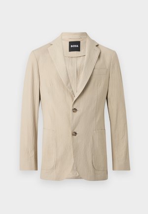 Blazer beige texturizzato con due bottoni, rever a intaglio, due tasche frontali e una tasca sul petto, con etichetta BOSS all'interno del colletto.