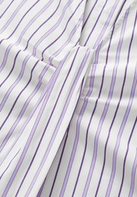 Tessuto bianco con strisce verticali di lavanda, caratterizzato da una texture morbida e un design drappeggiato con un dettaglio a patta anteriore.