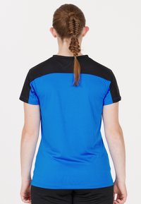 Kortärmad sportshirt med blå kropp, svarta axlar och blå sömmar. Slät textur, figurnära design lämplig för aktiv användning.