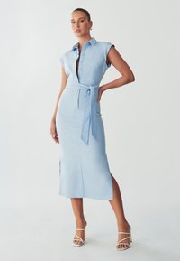 Himmelblaues, kurzärmliges Hemdkleid mit Knöpfen und tailliertem Gürtel. Es hat ein mittellanges Design und seitliche Schlitze für Bewegungsfreiheit.