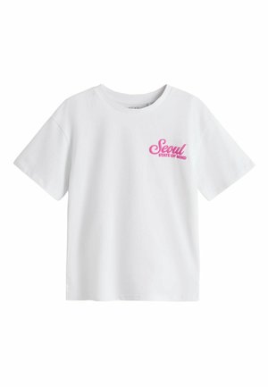 Hvid T-shirt med korte ærmer med lyserød tekst "Seoul State of Mind" på øverste venstre bryst, rund halsudskæring og løs pasform.