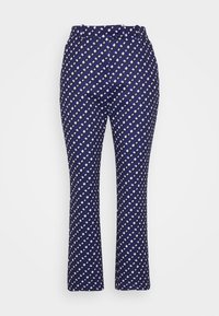 Pantalones impresos en azul marino, con un patrón geométrico en blanco y púrpura, de corte ajustado, con cinturilla y diseño de parte inferior acampanada.