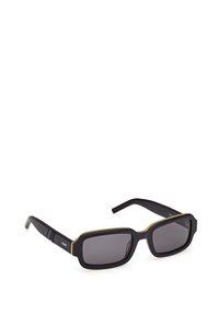 Mustat suorakulmaiset aurinkolasit, joissa on mattapinta, keltaisia korostuksia kehyksen reunoilla ja tummanharmaat linssit. Pyöristetyt kulmat ja leveät templet.