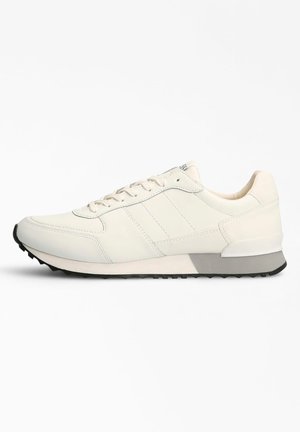 Zapatilla de piel blanca con punta redondeada, parte delantera con cordones, paneles texturizados y acentos grises en la entresuela y suela de goma.