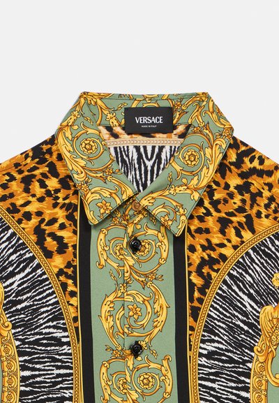 Majica s kratkim rukavima Versace s kombinacijom leopardovog i zebrinog uzorka, zlatnim detaljima, zelenim naglascima i crnim gumbima.