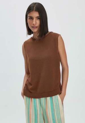 Bruine gebreide mouwloze top met een ronde halslijn en geribbelde zoom, gecombineerd met gestreepte pastelkleurige wijde broek. Zachte textuur en relaxte fit.