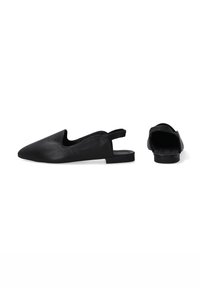 Czarne skórzane buty typu slingback z ostrymi noskami, płaskimi podeszwami i bezszwowym designem. Gładka tekstura o minimalistycznej, nowoczesnej estetyce.