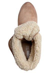 Bottine en daim beige avec doublure épaisse en shearling couleur crème repliée sur le dessus, vue de dessus.
