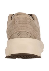 Beige mokka-tennis kengät verkkokangas yksityiskohdilla, paksulla kumipohjalla, nauhakiinnityksellä ja tekstuurilla varustetulla yläosalla. Takakuvassa korostuu brändäys.
