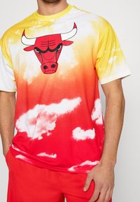 T-shirt z gradientem czerwono-żółtym, z grafiką byka, wzorem chmur, krótkimi rękawami i okrągłym dekoltem. Wykonana z lekkiego materiału.