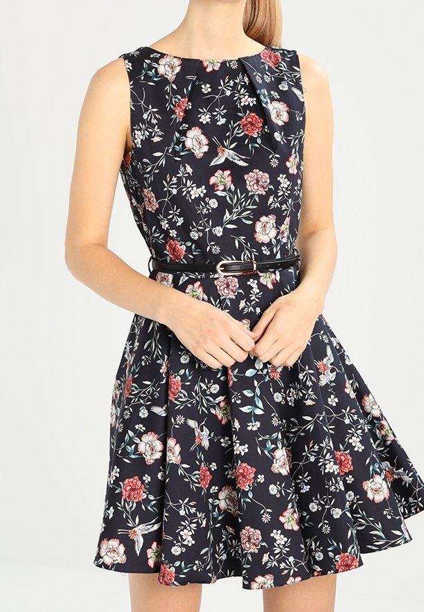 Blommig klänning med A-linjeform som har en marin bakgrund med flerfärgade blommönster, ärmlös design och midjebälte.