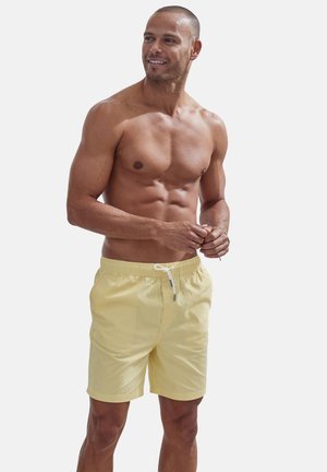 Helle gelbe Badehose aus weichem Stoff, mit einem elastischen Bund und weißem Kordelzug, mit lockerer Passform und geraden Beinen.