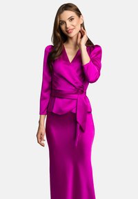 Fuksjowa bluzka z długim rękawem i detalem peplum, połączona z dopasowaną fuksjową spódnicą o slim fit, obie z gładkiego satynowego materiału.