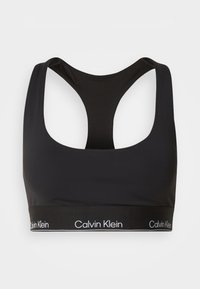 Melna sporta krūšturis ar ovālu izgriezumu un sacensību aizmuguri. Iezīmēts ar platu melnu joslu ar baltu "Calvin Klein" logotipu. Gluda tekstūra.