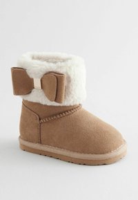 Jasnobrązowe zamszowe botki z fałszywym futrem przy mankiecie i dużą brązową kokardą z tyłu. Szyte detale i teksturowana podeszwa.