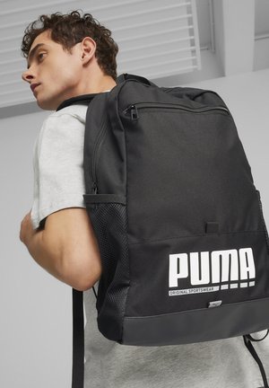 Črn nahrbtnik iz trpežne tkanine, z sprednjo žepno z zadrgo in mrežastima stranskima žepoma. Velik bel logotip in besedilo na sprednji strani.