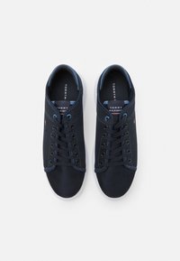 Sneakers a rete blu navy con punta tonda, suola bianca e lacci tono su tono. Presentano il marchio sulla linguetta e sul lato, e un interno blu a contrasto.