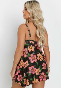 Vestido negro con flores, de tirantes finos, que presenta grandes flores rosas y naranjas, y hojas verdes, con un diseño de falda acampanada y textura de tela suave.