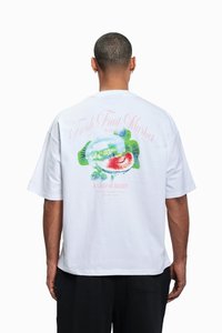 Hvit bomulls t-skjorte med et fargerikt fruktmotiv på baksiden med teksten "Fresh Fruit Market" i rosa og grønt. Løs passform.
