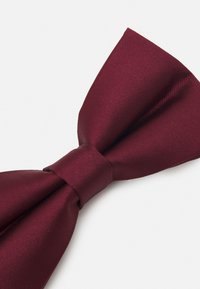Papion bordeaux dintr-un material neted, având o formă clasică cu un nod central și o suprafață texturată.