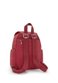 Mochila de tela roja con correas web ajustables, compartimento principal con cremallera y dos bolsillos laterales. Textura suave con acentos metálicos.