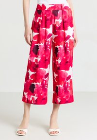 Pantalon large en imprimé floral rouge ; tissu léger avec des accents de rose vif et de noir ; dotés de plis et d'une ceinture lisse.