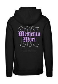 Svart hettegenser med en stor, hvit og lilla grafisk tekst "Memento Mori" på baksiden, med tilleggs tekst nederst i mindre skrifttype.