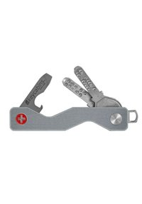 Metal key holder with a flat, curved design, featuring a red Swiss cross emblem, a bottle opener, and multiple gray keys.