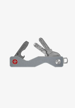 Metall-Schlüsselhalter mit flacher, gewölbter Form, versehen mit einem roten Schweizer Kreuz-Symbol, einem Flaschenöffner und mehreren grauen Schlüsseln.