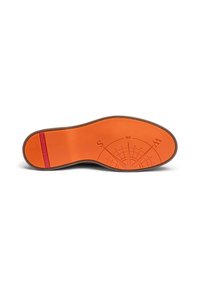 La semelle de la chaussure présente une surface orange vif avec un motif de boussole et une bande d'accent rouge. La forme est profilée avec des bords texturés.