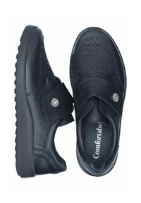 Schwarze Schuhe aus strukturiertem Leder mit einem Krokodilsmuster und einem Klettverschluss. Gepolsterte Sohle mit einem kleinen silbernen Akzentdetail.