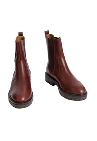 Bottes Chelsea en cuir marron avec des panneaux élastiques sur les côtés, bout arrondi et semelle en caoutchouc noire texturée. Bride au talon pour un enfilage facile.